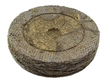 Round compressed peat soil pellet for seed starting and gardening on white background