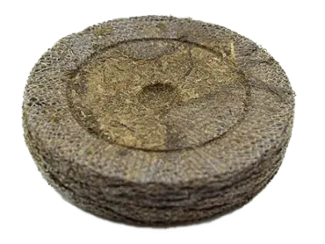 Round compressed peat soil pellet for seed starting and gardening on white background